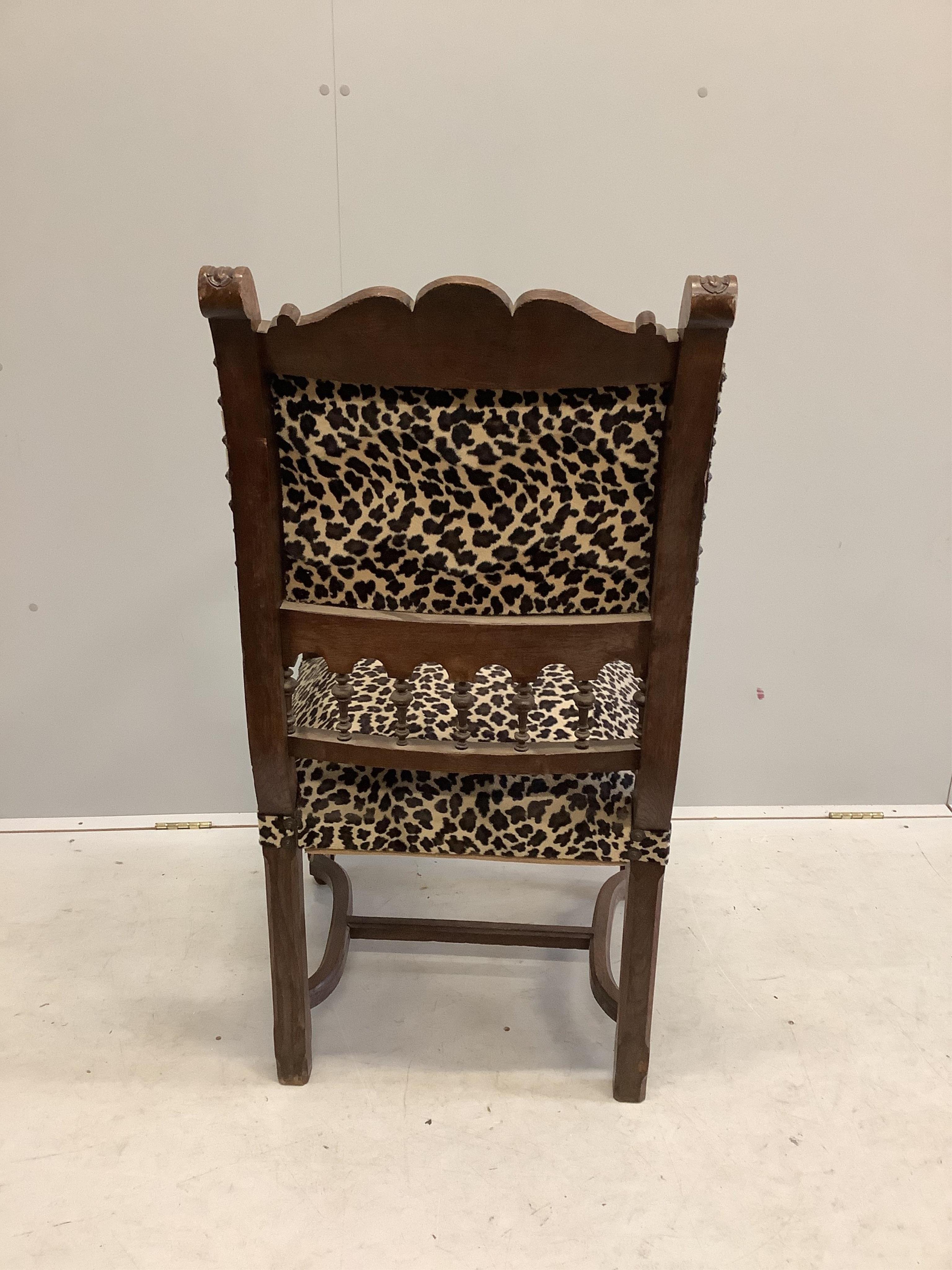 An oak elbow chair with leopard print fabric, and one other oak elbow chair, larger width 59cm, depth 65cm, height 112cm. Condition - fair